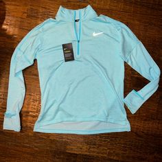 This Is A New With Tags Nike Running Long Sleeve 1/4 Zip Running Shirt. Color Is Aquamarine Or Pastel Blue. Has Never Been Worn. Smoke Free Home. No Stains. No Rips. This Top Was Originally Retailed For $89. Sale Price Was Tagged At $65. Reflective Nike Safety Swoosh On Front And “Dots” The Reflective On Back. Dri Fit Technology. Spring Sports Half-zip Top, Spring Half-zip Sports Top, Blue Fitted Half-zip Top, Blue Stretch Half-zip Top, Nike Athleisure Half-zip Tops, Blue Half-zip Top For Spring, Blue Stretch Nike Tops, Nike Blue Long Sleeve Tops, Nike Blue Tops For Spring