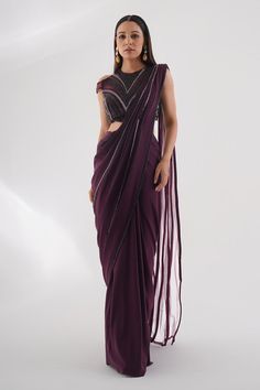 Burgundy lycra pre-draped saree with pleated draped detail and attached embroidered pallu. Paired with padded blouse with all over tonal cut dana, pearl and bead embroidery.
Components: 2
Pattern: Embroidered
Type Of Work: Bead, Stone, and Cut Dana Work
Neckline: Closed Neck
Sleeve Type: Cold Shoulder Sleeves
Fabric: Lycra
Color: Wine
Other Details: 
Embroidered sheer back
Pointed blouse hem
Saree Length: 44 inches
Occasion: Cocktail,Sangeet - Aza Fashions Formal Embellished Pre-draped Saree For Diwali, Formal Saree With Sequins In Traditional Drape, Elegant Purple Georgette Blouse, Embellished Purple Georgette Blouse Piece, Formal Choli With Mirror Work And Traditional Drape, Formal Blouse Piece With Traditional Drape, Draped Blouse With Mirror Work For Reception, Formal Choli With Sequins And Traditional Drape, Formal Georgette Blouse With Traditional Drape