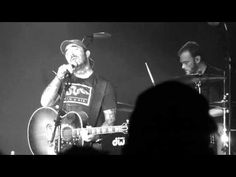 two men on stage playing guitars and singing