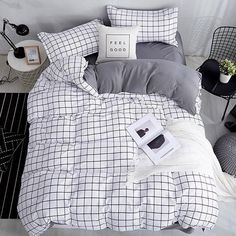 a bed with black and white plaid comforter, pillows and pictures on the wall