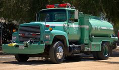 a large green truck parked on the side of a road