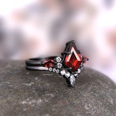 Introducing the stunning Skye Natural Red Garnet Kite Ring Set, a masterpiece crafted for those seeking an exquisite blend of elegance and contemporary style. This exceptional set features a breathtaking Black Rhodium Filled 925 Sterling Silver Engagement Ring, meticulously designed to capture the essence of sophistication and passion.►The centerpiece of this set is the enchanting Natural Red Garnet, carefully selected for its rich, deep hue and unparalleled brilliance, evoking a sense of timele Black And Red Ring, Kite Engagement Ring, Alchemy Gothic Jewelry, Red Engagement Ring, Garnet Sterling Silver Ring, Kite Ring, Garnet Wedding Rings, Garnet Wedding, Gothic Engagement Ring