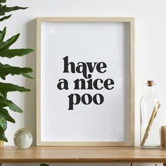 a black and white print with the words have a nice poo on it next to a potted plant