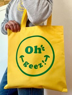 Oh Geez! Hope this tote bag makes you smile! Perfect tote for carrying all your goodies!  These bright yellow tote bags feature my Oh Geez! Design Smiley Wink Face design in green.  The totes measure 14 3/4 x 13 3/4 and have 28" inch handles.   Designed and printed in the Black Hills of SoDak! View my Oh Geez! Design Smiley Face T-shirts here: Fun Yellow Bags For Everyday Use, Fun Green Everyday Bags, Playful Yellow Bag For Everyday Use, Cute Yellow Cotton Bags, Green Novelty Bags For Daily Use, Yellow Eco-friendly Canvas Bag As Gift, Eco-friendly Yellow Canvas Bag As A Gift, Fun Canvas Tote Bag, Playful Yellow Everyday Bag