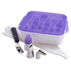 an ice box with tools in it sitting on a table next to some knives and spoons