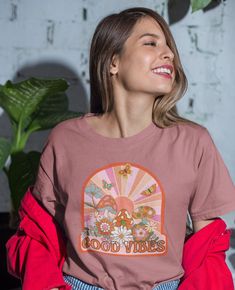 Retro aesthetic sunshine background with mushrooms, butterflies and flowers. This t-shirt is everything you've dreamed of and more. It feels soft and lightweight, with the right amount of stretch. It's comfortable and flattering for all.  *For oversized, relaxed look, size up to your preference. For actual sizing, refer to the size chart. * 100% combed and ring-spun cotton (Heather colors contain polyester) * Fabric weight: 4.2 oz/yd² (142 g/m²) * Pre-shrunk fabric * Side-seamed construction * Shoulder-to-shoulder taping * Blank product sourced from Guatemala, Nicaragua, Mexico, Honduras, or the US This product is made especially for you as soon as you place an order, which is why it takes us a bit longer to deliver it to you. Making products on demand instead of in bulk helps reduce overp Casual Mushroom Print T-shirt For Spring, Groovy Graphic Print Summer Shirt, Groovy Retro Print Summer Shirt, Hippie Tops With Funny Print For Spring, Groovy Retro Print Shirt For Summer, Spring Hippie Top With Funny Print, Hippie Top With Funny Print For Spring, Spring Cotton Tops With Mushroom Print, Spring Cotton Top With Mushroom Print