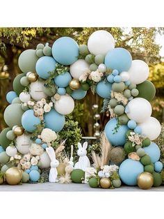 a blue and white balloon arch with some balloons in the shape of an easter bunny