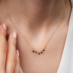 "This dainty onyx necklace is essential to light up your formal look in a delicate way. This onyx station necklace is ultra-light anda good choice for the minimalist jewelry movement. Five tiny black stones hang on a 14 k gold 16,5\" chain. Black stones measures 3mm in width. The adjustable chain with its 1,20\" extender secures with a spring-ring clasp. Due to its delicate design, good care of your jewelry is advised for long use. This onyx necklace is super gift for the women. Would you like t Elegant Black Necklaces For Evening, Elegant Black Necklace For Evening, Delicate Black Necklace For Gift, Elegant Black Onyx Necklace, Elegant Gold Necklaces With Black Diamonds, Elegant Onyx Necklace With Black Beads, Elegant Black Diamond Necklaces For Anniversary, Black Spinel Necklace With Black Beads For Gift, Gift Necklace With Black Spinel And Beads