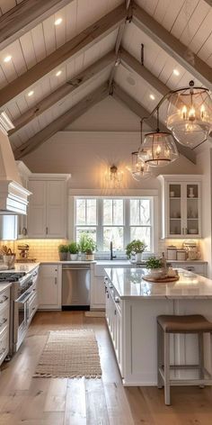 a large kitchen with white cabinets and wood flooring on the ceiling is lit by pendant lights