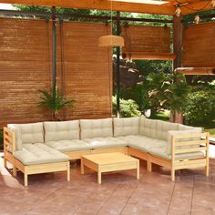 an outdoor living area with wooden furniture and plants