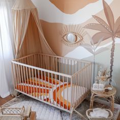 a baby's room with an orange and white crib in the corner, palm tree on the wall