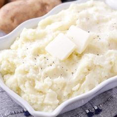 mashed potatoes with butter and seasoning in a white dish on a blue towel