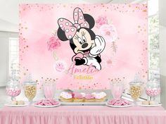 a table topped with cupcakes and cakes covered in minnie mouse frosted decorations