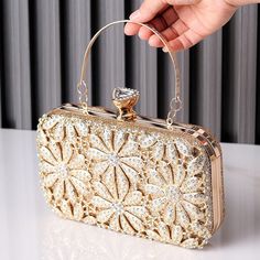 This clutch is a masterpiece of sheer elegance, boasting exquisite details that captivate the eye. From the delicate petals to the sparkling rhinestones that dance with every step, it's a symphony of beauty. Not only is it stunning, but it's also practical, lightweight, and easy to carry, ensuring you move gracefully through the night. With this clutch, beauty merges seamlessly with functionality, creating an unforgettable experience. Now available in gold and black. Chic Embellished Crystal Bag, Chic Crystal Bags For Events, Chic Embellished Crystal Evening Bag, Chic Evening Crystal Bags, Glamorous Crystal Evening Bag With Rhinestones, Chic Crystal Evening Bag For Events, Chic Crystal Evening Bag For Weddings, Glamorous Crystal Evening Bag With Bling, Glamorous Evening Bags With Crystal