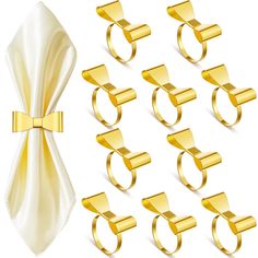 a set of gold rings and napkins on a white background with a bow tie