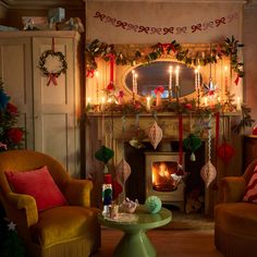 a living room filled with furniture and a fire place covered in christmas garlands next to a fireplace