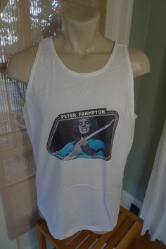 "All my pop t-shirts are vintage and in excellent shape. They may not be perfect but only with occasional minor flaws. All are very wearable and without significant flaws. Label: Oneita, L Chest: 44 Inches Around (22\" Arm pit to arm pit) / Length: 29.5\" Any Item Can Be Returned For Any Reason Within 4 Days of Receipt We take product infringement seriously. Our items are vintage shirts we find at thrift stores, antique malls and estate sales. We do no manufacture shirts. If you think one of our Vintage Cotton Top For Concert, Vintage Fan Merchandise Shirt For Summer, Vintage Cotton Shirt For Fan Merchandise, Pop Culture Cotton Top With Band Logo, Fitted Cotton T-shirt With Band Logo, Summer Pop Culture Cotton Shirt, Vintage Unisex Cotton Tops, Unisex Vintage Cotton Tops, Cotton Screen Print Top For Concerts