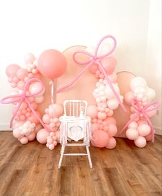 a chair and balloons in front of a wall