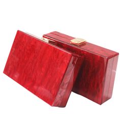 Introducing the Red Box Acrylic Clutch —a beautifully enchanting statement piece perfect for your next special occasion. Crafted from luxurious red pearlescent acrylic, this one-shoulder banquet clutch adds a touch of elegance to any ensemble. Its horizontal square box shape provides a structured, yet graceful design, complete with a secure top button closure. The soft lining ensures durability, while the option to carry it as a clutch or add a chain strap offers versatile styling. This beautifully crafted clutch is the perfect way to enchant your evening and elevate your look with effortless beauty. Chic Rectangular Clutch For Wedding Guest, Square Red Clutch, Rectangular Box Bag For Gifts, Burgundy Rectangular Clutch For Evening, Burgundy Rectangular Evening Clutch, Rectangular Burgundy Evening Clutch, Chic Burgundy Rectangular Clutch, Glamorous Rectangular Box Bag For Gift, Rectangular Burgundy Clutch For Party