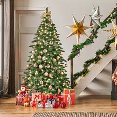 a christmas tree with presents under the stairs