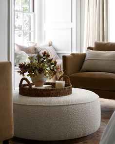 a living room filled with furniture and a flower pot on top of a coffee table