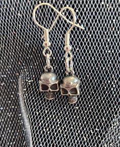 Metal skull charm on silver earring hooks, handmade Silver Skull Earrings For Halloween, Gothic Skull Metal Earrings, Gothic Sterling Silver Skull Earrings, Skull Shaped Metal Earrings, Silver Skull Earrings With Ear Wire, Silver Skull Earrings For Pierced Ears, Gothic Skull Shaped Pierced Earrings, Handmade Silver Skull Jewelry, Skull Shaped Metal Earrings For Gifts