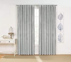 the blue curtains are hanging in front of a white table and window with an open curtain