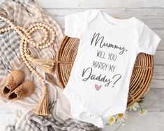 Mummy, Will You Marry My Daddy? Get the baby involved in your proposal using this cute baby vest. The short sleeved baby vest is printed using the highest quality inks ensuring a long lasting design. The vest is a super soft feel made from 65% polyester and 35% cotton, with 3 Nickel free poppers. The romper features an envelope neck to help with easy dressing and undressing. Available in Newborn, 0-3, 3-6, 6-12 and 12-18 months. Please see our second photo for a size guide if you are unsure whic Proposal Ideas Engagement, Godmother Gifts, Engagement Ideas, Cotton Bodysuit, Baby Vest, Gender Neutral Baby Clothes, Proposal Ideas, Baby Shirts, Baby Grows