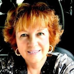 a woman sitting in the back seat of a car looking at the camera with green eyes