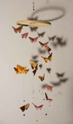 a group of butterflies are flying in the air and suspended from a circular chandelier