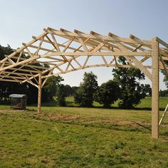 a wooden structure sitting in the middle of a field