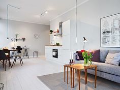 a living room filled with furniture next to a kitchen and dining room table in front of a window