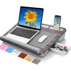 an open laptop computer sitting on top of a mouse pad next to a cell phone