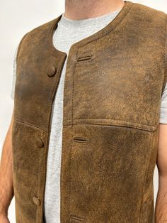 Perfect for three seasons, with the choice to layer on cooler days. Our sheepskin vest are durable, stylish and 100% natural allowing for your body to regulate warm in a productive way. Do you hate how body heat feels from polyester or synthetic fabrics? Then natural sheepskin and wool is the right choice for you. Our rancher vest is made from 100% leather and lined with 100% black mutton sheepskin. Our first model is wearing a size Large, is 6’ 5” and 175 pounds Our second model is wearing a si Rugged Winter Vest For Outdoor Activities, Rugged Outdoor Winter Vest, Rugged Brown Vest For Fall, Rugged Brown Winter Vest, Brown Rugged Vest For Winter, Brown Rugged Winter Vest, Fitted Sleeveless Rugged Outerwear, Leather Winter Outdoor Vest, Rugged Brown Vest Outerwear