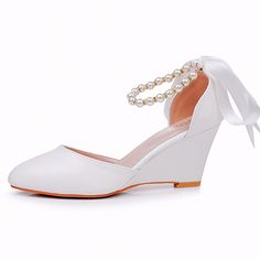 a pair of white shoes with pearls on the heel