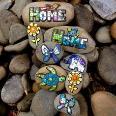 some rocks with painted words on them and flowers in the middle one that says hope