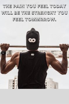 a man in a black tank top is holding a bar