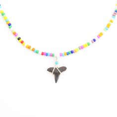 a multicolored beaded necklace with a black bird charm hanging from it's center