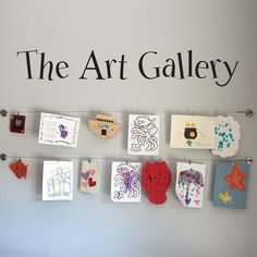 the art gallery is organized with cards and magnets on a white wall behind it