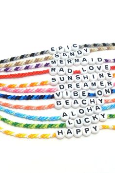 four bracelets with words written on them in different colors and sizes, one is multicolor