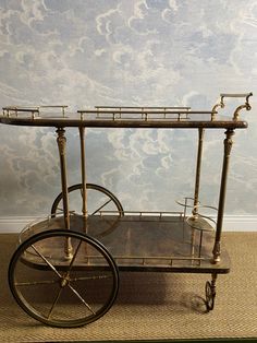 an antique brass bar cart with wheels on carpeted floor