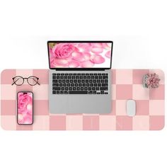 an open laptop computer sitting on top of a pink checkered desk