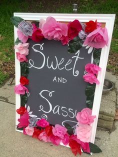 a chalkboard sign decorated with pink and red flowers