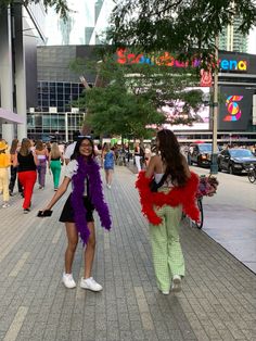 two women dressed in costumes walking down the street