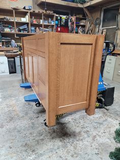 a wooden bed frame sitting on top of a floor next to a pile of tools