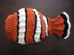 an orange and white striped knitted hat on a wooden surface with black stripes,