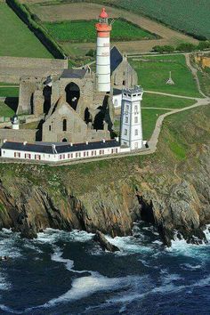 an aerial view of a lighthouse near the ocean