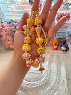 a hand is holding some beads in it's palm and there are other items on the table