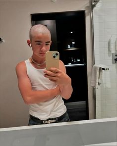 a man taking a selfie in front of a bathroom mirror with his cell phone