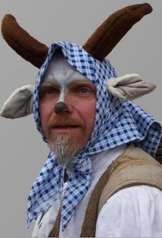 a man with white paint on his face and antlers on his head, wearing a costume